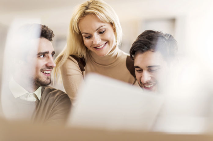 Drei moderne Geschäftsleute mit Laptop gemeinsam im Büro.